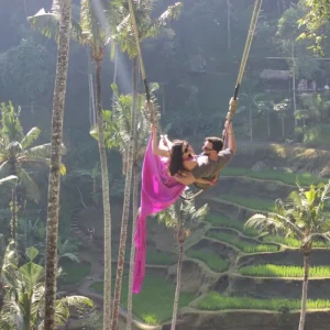 Couple on a Bali swing with a view of green rice terraces
